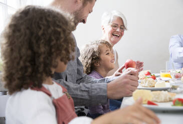 Glückliche Großfamilie beim Mittagessen zu Hause - MJFKF00110