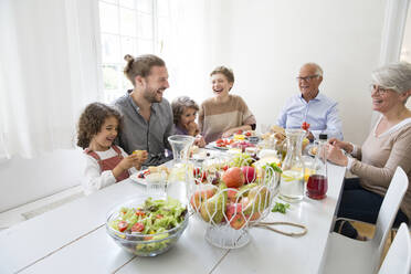 Glückliche Großfamilie beim Mittagessen zu Hause - MJFKF00119