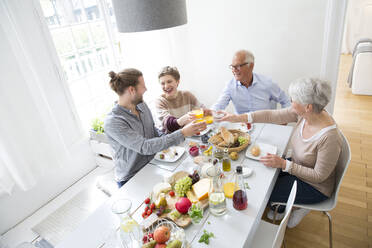 Happy senior couple with adult children having lunch at home - MJFKF00120