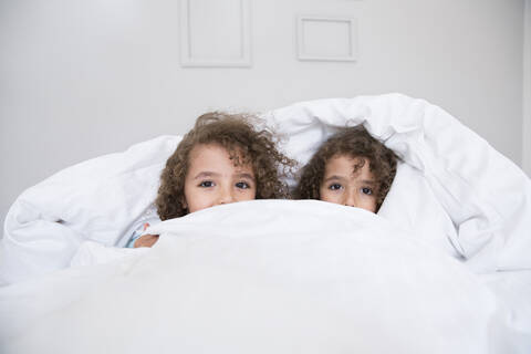 Porträt von zwei niedlichen Zwillingsbrüdern im Bett, lizenzfreies Stockfoto
