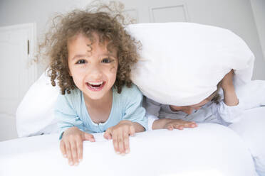 Portrait of happy boy with his brother in bed - MJFKF00161