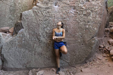 Junge asiatische Frau klettert in einer Felswand - JPTF00302