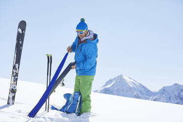 Skitourengeher beim Anbringen des Fells am Ski in den Bergen, Kühtai, Tirol, Österreich - CVF01496