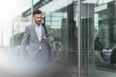 Businessman using cell phone in the city - DIGF08422