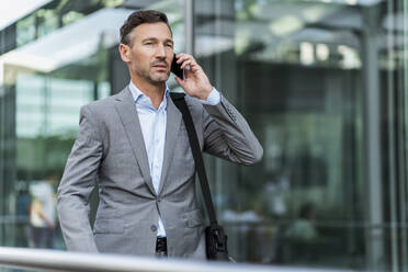 Businessman on cell phone in the city - DIGF08424