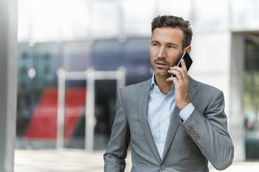 Businessman on cell phone in the city - DIGF08432