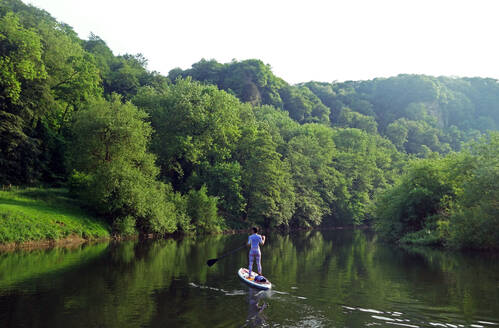 Paddle boarder deep in the Wye Valley Gorge, River Wye, Monmouthshire, Wales, United Kingdom, Europe - RHPLF09206