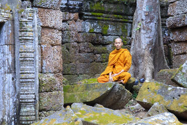 Buddhist monk sitting in a ruined temple in Angkor, UNESCO World Heritage Site, Siem Reap, Cambodia, Indochina, Southeast Asia, Asia - RHPLF09225