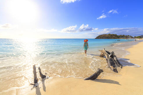Rückansicht einer Frau mit Hut, die am Ffryes Beach spazieren geht, Antigua, Antigua und Barbuda, Leeward Islands, Westindien, Karibik, Mittelamerika - RHPLF09243