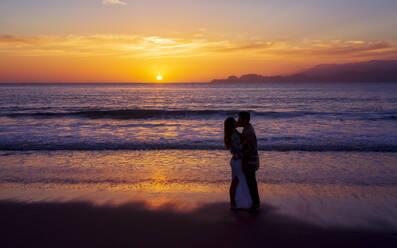 Sunset and couple in love near the Golden Gate Bridge, Baker Beach, San Francisco, California, United States of America, North America - RHPLF09437