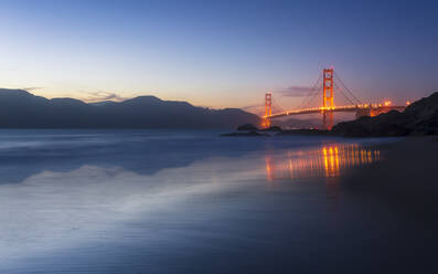Soft flowing water reflects the beautiful Golden Gate Bridge from Baker Beach, San Francisco, California, United States of America, North America - RHPLF09439
