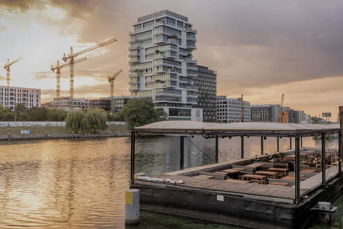 Blick auf die Spree nach Sonnenaufgang in Berlin mit modernen Gebäuden im Hintergrund, Berlin, Deutschland, Europa - RHPLF09474