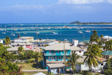 Blick auf Clifton und den Hafen von Clifton, Union Island, mit Palm Island in der Ferne, Die Grenadinen, St. Vincent und die Grenadinen, Westindische Inseln, Karibik, Mittelamerika - RHPLF09491