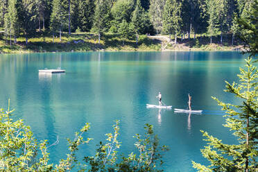 Junges Paar übt Stand Up Paddling, Caumasee, Flims, Bezirk Imboden, Kanton Graubünden, Schweiz, Europa - RHPLF09575