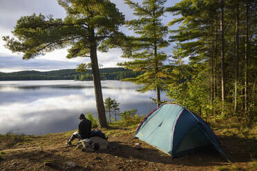 Hiker camping by Provoking Lake in Algonquin Provincial Park, Ontario, Canada, North America - RHPLF09630
