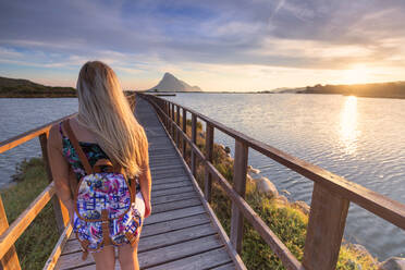 Ein Mädchen betrachtet den Sonnenaufgang von einem Fußgängerweg aus, Porto Taverna, Loiri Porto San Paolo, Olbia Tempio Provinz, Sardinien, Italien, Mittelmeer, Europa - RHPLF09737