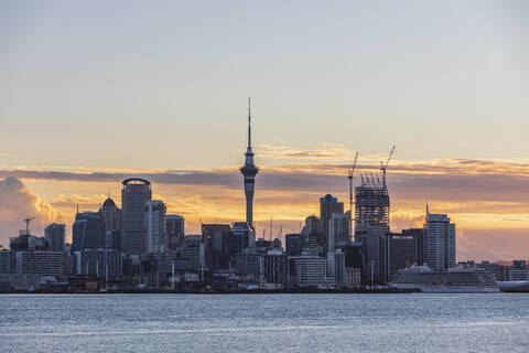 Modern buildings by sea against cloudy sky at sunset, Oceania, New Zealand stock photo