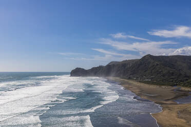 Blick auf eine Klippe am Meer gegen den blauen Himmel am Piha Beach, Auckland, Neuseeland - FOF10926