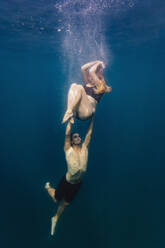 Junges Paar unter Wasser, Frau schwanger - KNTF03412