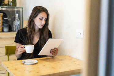 Young woman using tablet in a cafe - GIOF07078