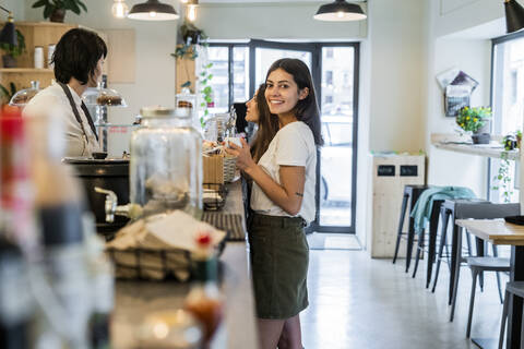 Two happy young female friends at the counter in a cafe stock photo
