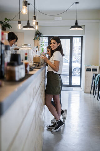 Two happy young female friends at the counter in a cafe stock photo