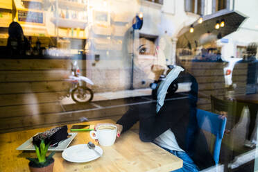 Portrait of a young woman in a cafe behind the windowpane - GIOF07108