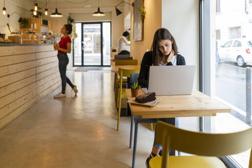 Junge Frau mit Laptop in einem Café - GIOF07122