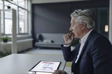 Älterer Geschäftsmann mit Tablet und Architekturplan - GUSF02552