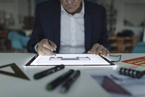Close-up of senior businessman drawing on shining tablet - GUSF02561