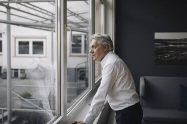 Senior businessman looking out of the window - GUSF02567