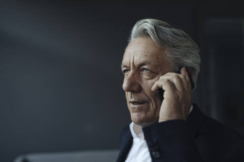 Porträt eines älteren Geschäftsmannes, der mit einem Mobiltelefon spricht, lizenzfreies Stockfoto