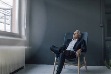 Älterer Geschäftsmann sitzt mit geschlossenen Augen im Sessel - GUSF02615