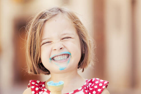 A happy girl eating a blue ice cream - XCF00213