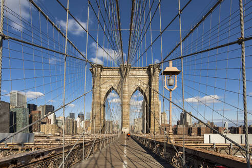 Verkleinernde Perspektive der Brooklyn Bridge vor blauem Himmel in New York City, USA - XCF00215