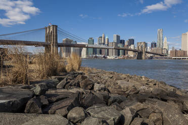 Brooklyn Bridge over East river against blue sky in New York City, USA - XCF00216