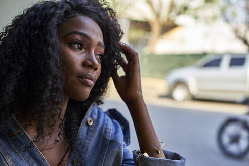 Portrait of young African woman in a cafe, looking out of window - VEGF00687