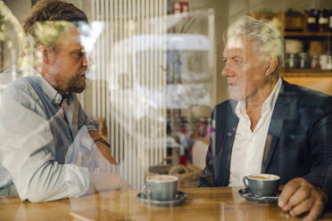 Zwei Geschäftsleute treffen sich in einem Cafe - GUSF02620