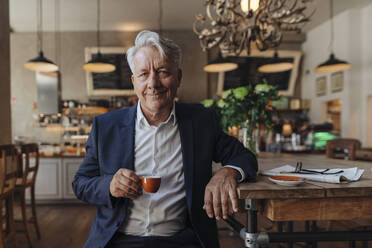 Porträt eines älteren Geschäftsmannes, der in einem Café Espresso trinkt - GUSF02627