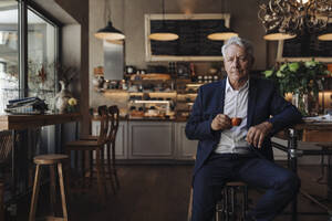 Porträt eines älteren Geschäftsmannes, der in einem Café Espresso trinkt - GUSF02647