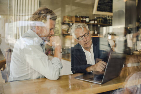 Zwei Geschäftsleute mit Laptop treffen sich in einem Cafe, lizenzfreies Stockfoto