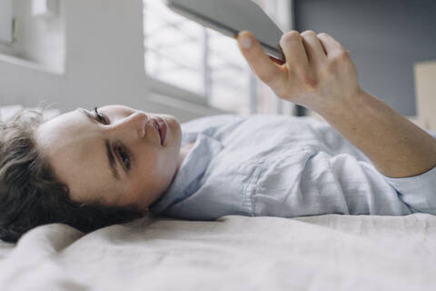 Junge Frau verwendet digitales Tablet zu Hause, lizenzfreies Stockfoto