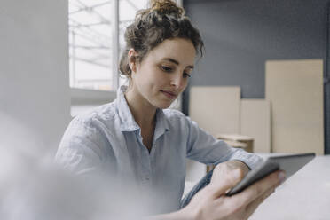 Portrait of young woman using digital tablet at home - KNSF06570