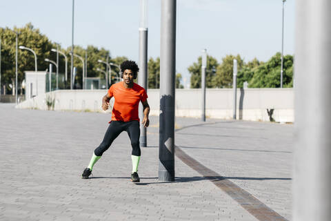 Junger Mann joggt in der Stadt und hört Musik, lizenzfreies Stockfoto