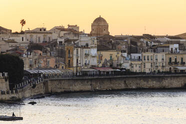 Sonnenaufgang über Ortigia (Ortygia), vom Meer aus, Fischer auf Pier, Syrakus (Siracusa), UNESCO-Weltkulturerbe, Sizilien, Italien, Mittelmeer, Europa - RHPLF09980