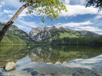 Snow-capped mountains reflected in the calm waters of Phelps Lake, Grand Teton National Park, Wyoming, United States of America, North America - RHPLF10120