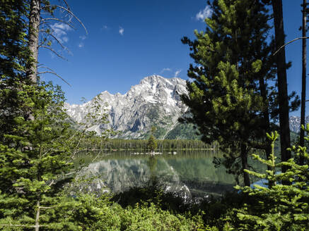 Schneebedeckte Berge spiegeln sich im ruhigen Wasser des Leigh Lake, Grand Teton National Park, Wyoming, Vereinigte Staaten von Amerika, Nordamerika - RHPLF10122