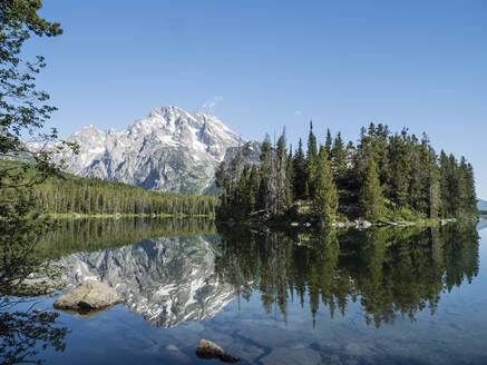 Schneebedeckte Berge spiegeln sich im ruhigen Wasser des Leigh Lake, Grand Teton National Park, Wyoming, Vereinigte Staaten von Amerika, Nordamerika - RHPLF10123