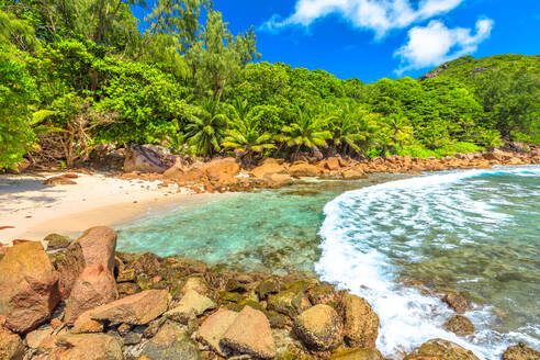 Abgelegener Caiman-Strand zwischen Anse Fourmis und Anse Cocos, geschützt durch riesige Felsformationen, La Digue, Seychellen, Indischer Ozean, Afrika - RHPLF10307