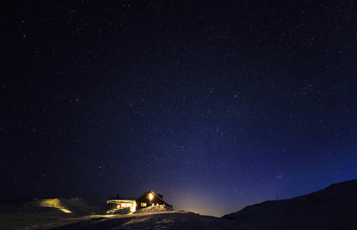 Beleuchtetes Haus im Winter - JOHF00386